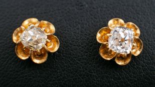 A pair of cushion-cut diamond ear studs,: estimated total diamond weight ca. 1.