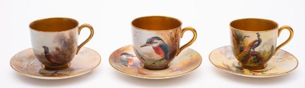 A group of six Royal Worcester porcelain coffee cups and saucers: three painted with pheasants,