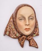 A Lenci pottery wall mask: modelled by Helen Konig Scavini as a young woman wearing a brightly