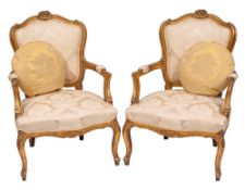 A salon suite of four carved and giltwood and damask upholstered bergères and a canapé in Louis XV