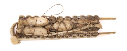 An Inuit whalebone model of a sled: laden with seals, guns, cartridge bag and shot flask, 12.
