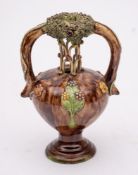 Two slipware pottery vases: comprising a two-handled vase applied with concentric bands of leaves