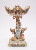 A large Continental porcelain figural centrepiece: of pierced rococo form applied with flowers and