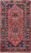 A Hamadan rug:, the rose hexagonal field with serrated ends, geometric designs and indigo spandrels,