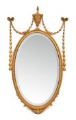 A pair of giltwood and composition framed oval wall mirrors in the Adam style, early 20th century,
