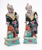 A pair of Chinese porcelain figures: of the immortal Li Tieguai stood in loose robes with one foot