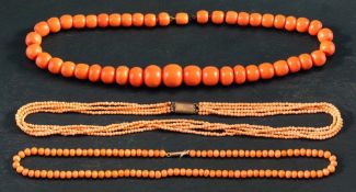 Three coral necklaces,: one single row of graduated deep pinkish orange beads, diameter ca. 8.2-14.