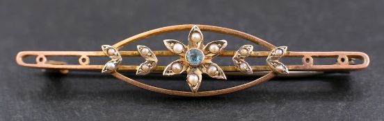 An openwork, seed pearl and blue topaz brooch with stylised floral decoration,