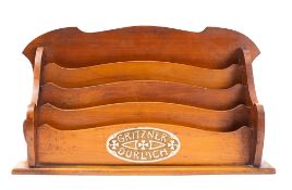 A 19th Century mahogany four division stationery rack: of arched outline,