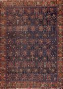 A Khamseh rug:, the indigo field with an all over design of geometric flowerhead medallions,
