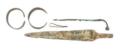 An ancient spear head or dagger blade: two metal bangles and a hair pin.