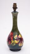 A Moorcroft pottery lamp: of slender pear shaped form tube lined in the Hibiscus pattern in yellow,