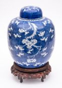A Chinese porcelain jar and cover: of oviform with domed cover, painted in blue with prunus,