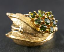 An andalusite ring of stylised foliate design,: stamped '750', length of ring head 2.