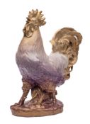 A large Continental porcelain figure: of a crowing cockerel on an oval rustic base,