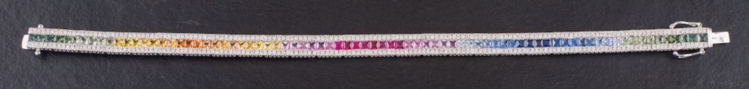 An 18ct white gold bracelet set with vari-coloured, mixed-cut coloured sapphires,: some synthetic,