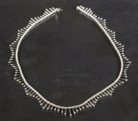 A fringed choker necklace set with round, brilliant-cut diamonds,