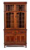 A late Victorian or Edwardian walnut and glazed cabinet bookcase in Arts and Crafts style,