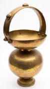An Indian brass spittoon: of ovoid form with loop handle, decorated with scenes of a tiger hunt,