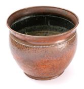 An Arts and Crafts influence hammered copper jardiniere: of circular form with flared rim,