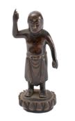 A bronze figure of a Buddha: standing on a lotus with arm raised, 14cm high.