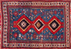 A Kazak rug:, the pastel blue field with triple serrated lozenge medallions in red surrounds,