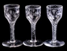 A set of three English wine glasses: each ogee bowl engraved with hops and a rose spray,