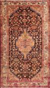 A Melayer rug:, the indigo field with a central shaded brick red lozenge pole medallion,