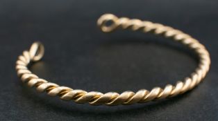 A barleytwist torque bangle,: stamped '18C', inner diameter ca. 6.1cms, total weight ca. 26.8gms.
