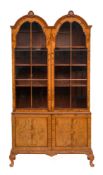 A walnut and crossbanded double arch topped cabinet bookcase in Queen Anne style, 20th century,