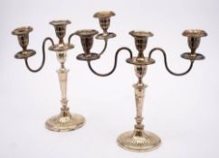 A pair of plated twin branch candelabra: with oval fluted sconces, on swept reeded branches,