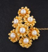 An 18ct gold and cultured pearl brooch in the form of a spray of flowers,