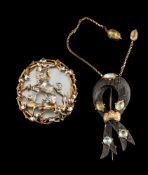 An oval, mother-of-pearl brooch,: the two greyhounds within a foliate surround, length ca. 4.