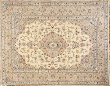 A Kashan carpet:, the ivory cartouche field with a central beige shaped oval pole medallion,