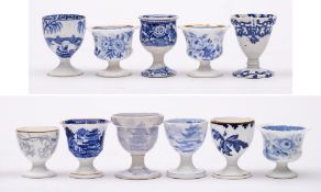 A group of eleven 19th Century blue and white transfer printed pottery and porcelain egg cups:,