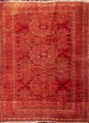 An Afghan Turkoman rug:, the red and brick red field with triple geometric medallions,