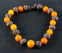 A carved seed pod and amber bead necklace and a Scottish carnelian and jasper bracelet,