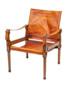 A stained beech and leather covered elbow chair in the manner of campaign furniture, modern,
