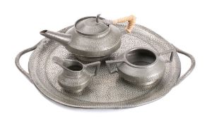 An Arts & Craft influence pewter three-piece tea service: together with circular serving tray with
