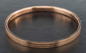 A 9ct gold bangle with engraved decoration,: hallmarks for Birmingham, 1926, inner diameter ca.