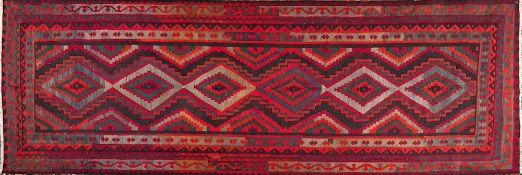 A Quashgai kelim:, the field with a row of six lozenge and stepped medallions,