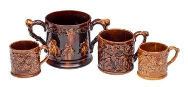 A large 19th century treacle-glazed frog loving-cup and three similar mugs: the exteriors with