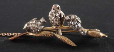 A Victorian, gold and silver brooch depicting three swallows on a bullrush,: with gemset eyes,