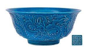 A Chinese blue ground 'Dragon' bowl: the exterior decorated in relief with three scally dragons