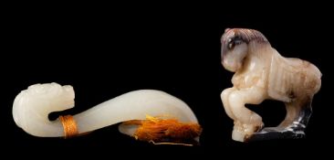 A Chinese jade dragon belt hook and a carving of a rearing horse: the belt hook of even celadon