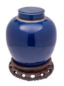 A Chinese powder blue ovoid jar and cover: Qing dynasty, 23cm (cover damaged) and wood stand.