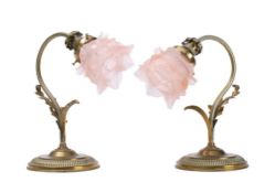 A pair of brass wall lights: on acanthus capped swept supports with circular backplates,