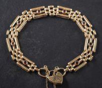 A 9ct gold gate-link, garnet bracelet with heart-shaped clasp,: with hallmarks for London, 1972,