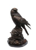 A 20th century bronzed metal study of a large bird of prey: perched on a naturalistic base,