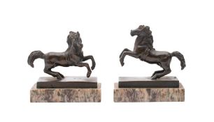 A pair of 17th century bronze models of rearing horses: mounted on rectangular polished marble